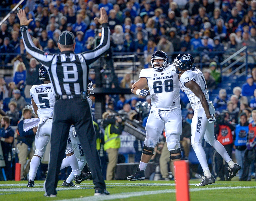 Leah Hogsten  |  The Salt Lake Tribune  Utah State Aggies wide receiver Ron'quavion Tarver (1) celebrates his touchdown in the 2nd quarter with teammate Utah State Aggies offensive lineman Moroni Iniguez (68) as BYU hosts Utah State University at Lavell Edwards Stadium in Provo, Friday, Oct. 5, 2018.
