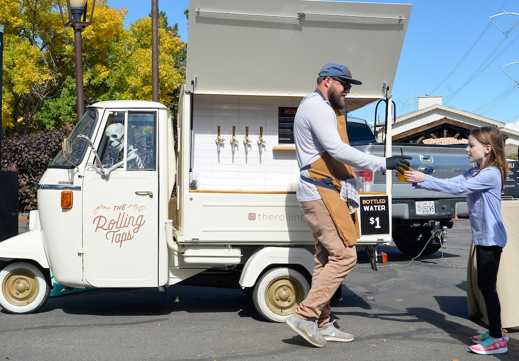 (Chris Samuels | The Salt Lake Tribune) Tyson Guthrie fills drink orders with The Rolling Taps during WitchFest at Gardner Village in West Jordan, Friday, Oct. 13, 2023.