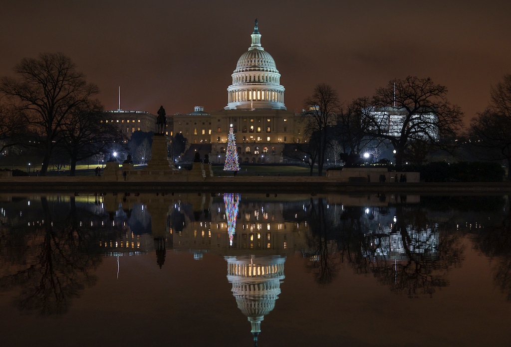 The Capitol is mirrored in the Reflecting Pool in Washington, as a partial government shutdown heads into a second week, Friday night, Dec. 28, 2018. Both chambers of Congress are gone, likely leaving the impasse till next week when the Democrats take control of the House of Representatives. (AP Photo/J. Scott Applewhite)