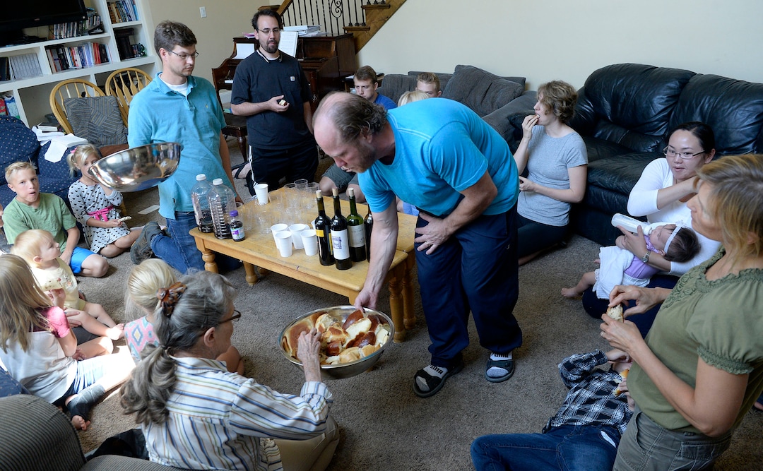 (Al Hartmann  |  The Salt Lake Tribune)
Believers in Denver Snuffer's Remnant movement meet in a Sandy home Sunday, Aug. 13, to sing songs and take the sacrament.  Ken Jensen, who is hosting the group, passes the sacrament bread to the group.