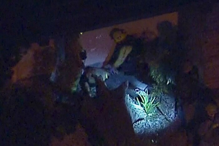 In this image made from aerial video, officials tend to a person on the ground in the vicinity of a shooting in Thousand Oaks, California, early Thursday, Nov. 8, 2018. Authorities say there were multiple injuries _ including one officer _ after a man opened fire in Southern California bar late Wednesday. (KABC via AP)