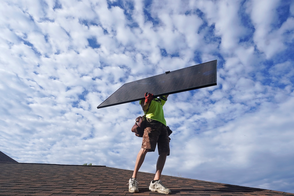 (Rick Bowmer | AP) A worker installs a solar panel in Salt Lake City in 2022.  A Massachusetts-based solar installation company has laid off 60 workers at its Provo location.