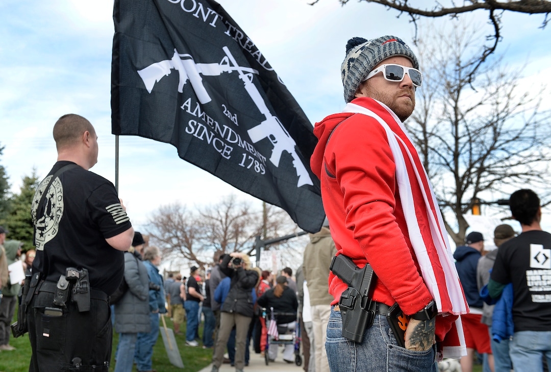 Scott Sommerdorf | The Salt Lake Tribune
Zach Dunn of Salt Lake City carried his Glock 9mm as he rallied with other pro-gun March Before Our lives marchers across the street from West High School, Saturday, March 24, 2018.
