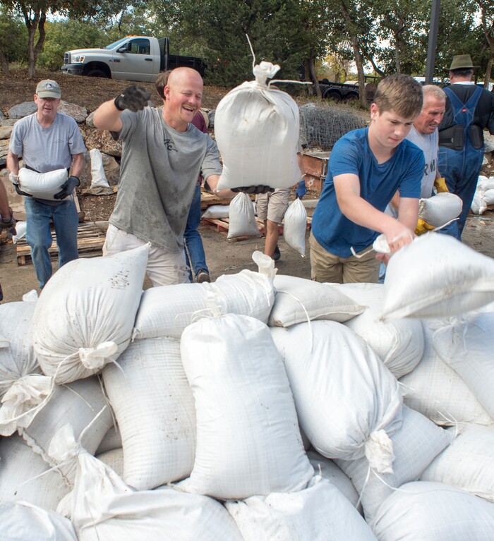 (Rick Egan  |  The Salt Lake Tribune)     Marcus Pierce and Chris Brockbank helps their neighbors from Woodland Hills stack sandbags, Monday, Oct. 1, 2018.



