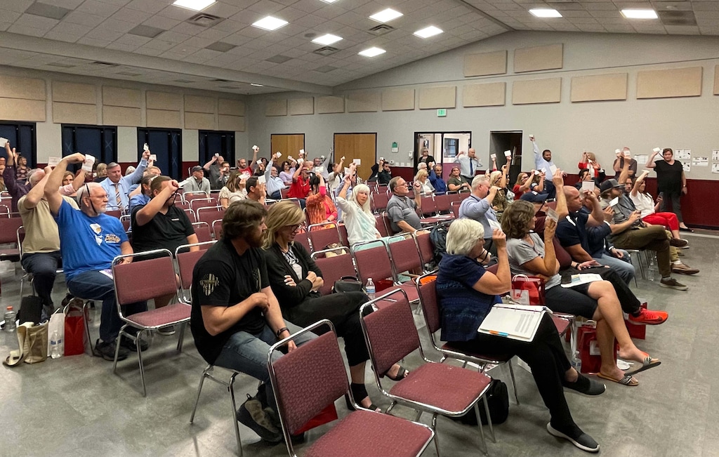 (Bryan Schott | The Salt Lake Tribune) Utah Republican State Central Committee members raise their credentials to vote in favor of a resolution to ban critical race theory in the state's schools.