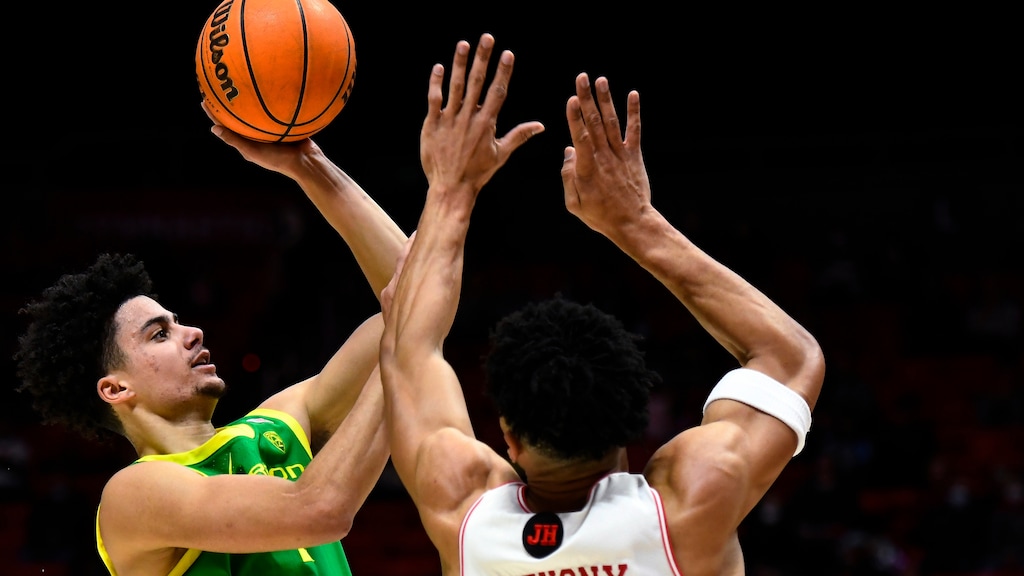 Oregon guard Will Richardson, left, shoots over Utah guard Marco Anthony during the first half of an NCAA college basketball game Saturday, Feb. 5, 2022, in Salt Lake City. (AP Photo/Alex Goodlett)