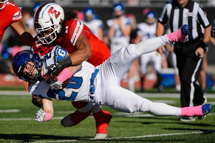 (Trent Nelson | The Salt Lake Tribune)
Pleasant Grove's Dayne Christiansen (20) is tackled by East's Sione Angilau (11) as East hosts Pleasant Grove in the first round of the 6A high school football playoffs, Friday Oct. 26, 2018.