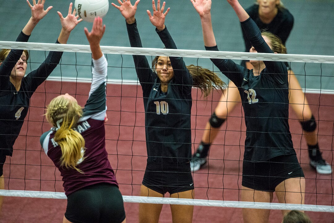 Chris Detrick  |  The Salt Lake TribuneMorgan's Marcie Stapley (9) spikes the ball past Desert Hills' Madison Clark (10) Desert Hills' Charity Bradley (12) and Desert Hills' Saselah Goulding (4) during the Class 3A state volleyball championship match Thursday October 27, 2016. 