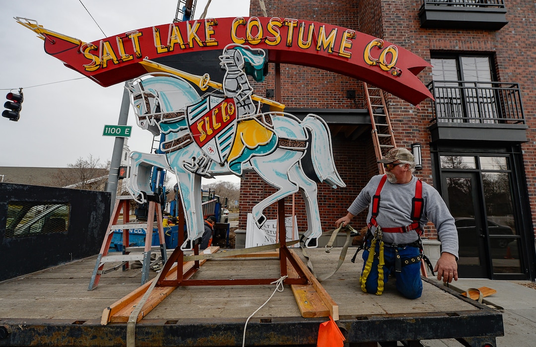 (Francisco Kjolseth  |  The Salt Lake Tribune) Cory Barker of Rainbow Neon Sign Co. prepares the Salt Lake Costume Co. sign, as it goes back to its original location at 1700 S. 1100 East on Monday, Dec. 23, 2019, in what is now called the Salt Lake Costume Apartments.