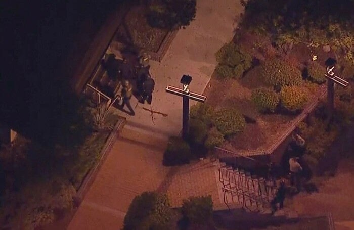 In this image made from aerial video, police move through the vicinity of a shooting in Thousand Oaks, California, early Thursday, Nov. 8, 2018. Authorities say there were multiple injuries - including one officer - after a man opened fire in Southern California bar late Wednesday. (KABC via AP)