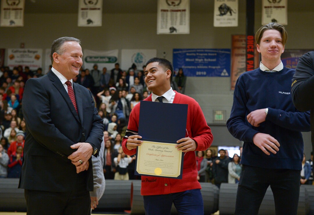 (Leah Hogsten  |  The Salt Lake Tribune) West High School students, Felix Ortiz, center, and Grant Dunkley, right, smile  as they are recognized for saving the life of Assistant Attorney General David Carlson, left, during an assembly at the school, Jan. 17, 2020. On February 19, 2019, Ortiz and Dunkley both pulled over to assist Carlson out of  his overturned car on the 600 North bridge in Salt Lake City where Ortiz performed life-saving CPR until first responders arrived on the scene.