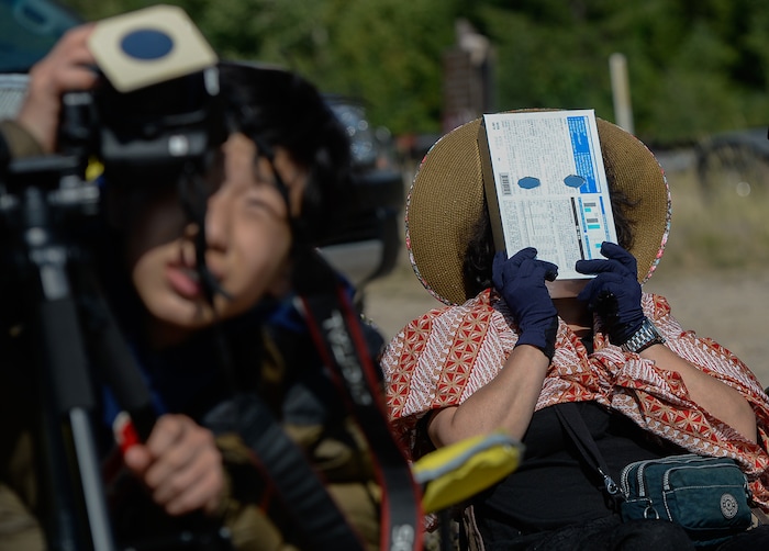 (Francisco Kjolseth  |  The Salt Lake Tribune)  Jong Ran Kim of South Korea uses a hand crafted viewer to take in the total eclipse of the sun from the edge of Palisades Reservoir, Idaho, on Monday, August 21, 2017.
