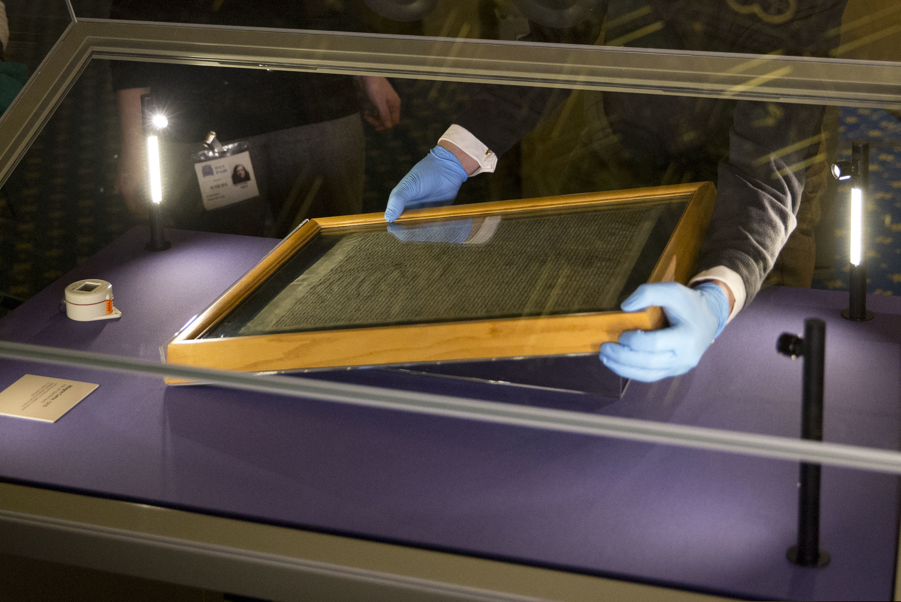FILE - In this file photo dated Thursday, Feb. 5, 2015, The Salisbury Cathedral 1215 copy of the Magna Carta is installed in a glass display cabinet marking the 800th anniversary of the sealing of Magna Carta at Runnymede in 1215, in Salisbury, England.  British police said Friday Oct. 26, 2018, that cathedral alarms sounded Thursday afternoon when a person tried to smash the glass display box surrounding the Magna Carta in Salisbury Cathedral, and a man has been arrested. (AP Photo/Matt Dunham, FILE)