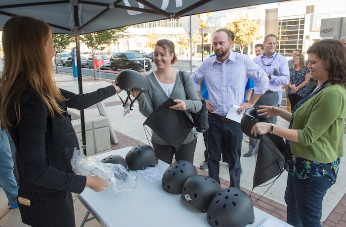 (Rick Egan  |  The Salt Lake Tribune)      Kaitlyn Murray, passes out free helmets courtesy of Bird scooters, at a news conference, about the new campaign with e-scooter companies Lime and Bird in an effort to help residents and visitors understand the rules of the sidewalk, Wednesday, Oct. 3, 2018.



