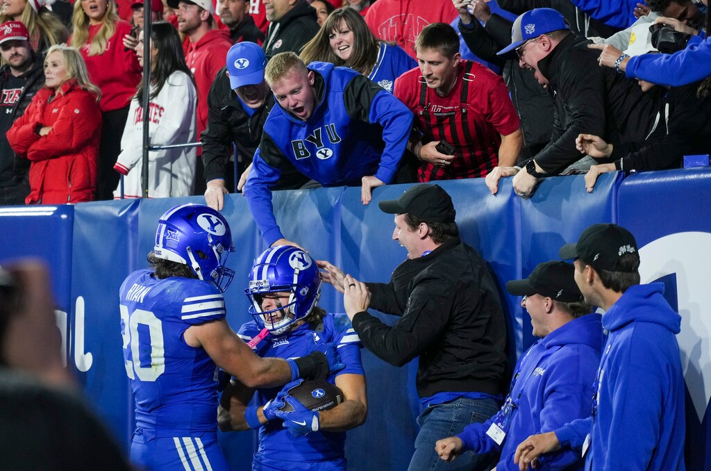 (Bethany Baker | The Salt Lake Tribune) BYU Cougars wide receiver Parker Kingston (11) and BYU Cougars tight end Carsen Ryan (20) celebrate with fans after a touchdown during the game between the BYU Cougars and the Utah Utes in Provo on Saturday, Oct. 18, 2025.
