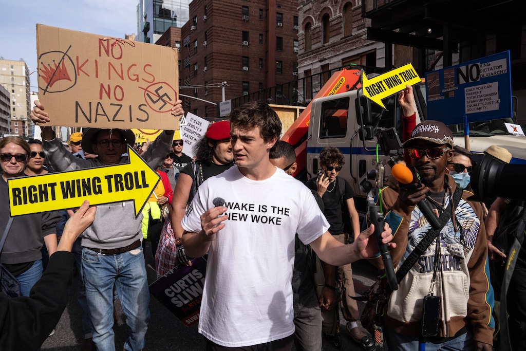 (Adam Gray | The New York Times) The YouTuber Nick Shirley records himself during the No Kings protest in New York on Oct. 18, 2025. Shirley's breakthrough came about five weeks ago, when he posted a 43-minute video claiming to expose fraud at about a dozen Somali-run day care centers in Minnesota.