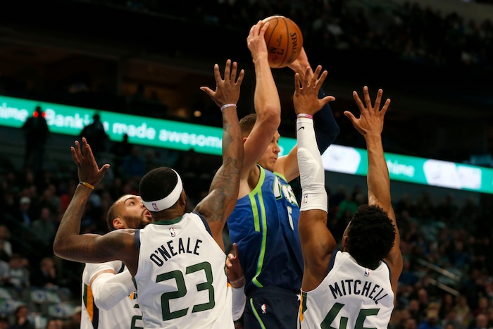 Utah Jazz center Rudy Gobert, left, Royce O'Neale (23) and guard Donovan Mitchell (45) defend against Dallas Mavericks forward Kristaps Porzingis (6) during the first half an NBA basketball game in Dallas, Monday, Feb. 10, 2020. (AP Photo/Michael Ainsworth)