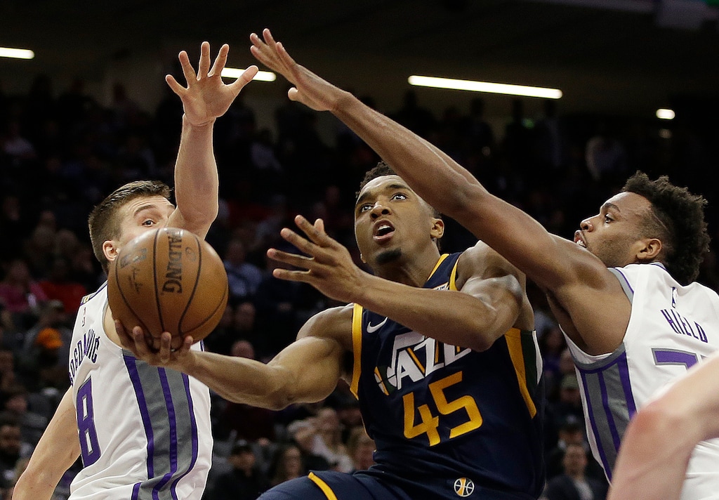 Utah Jazz guard Donovan Mitchell, center, drives to the basket between Sacramento Kings' Bogdan Bogdanovic, left, and Buddy Hield during the second half of an NBA basketball game Wednesday, Jan. 17, 2018, in Sacramento, Calif. The Jazz won 120-105. (AP Photo/Rich Pedroncelli)