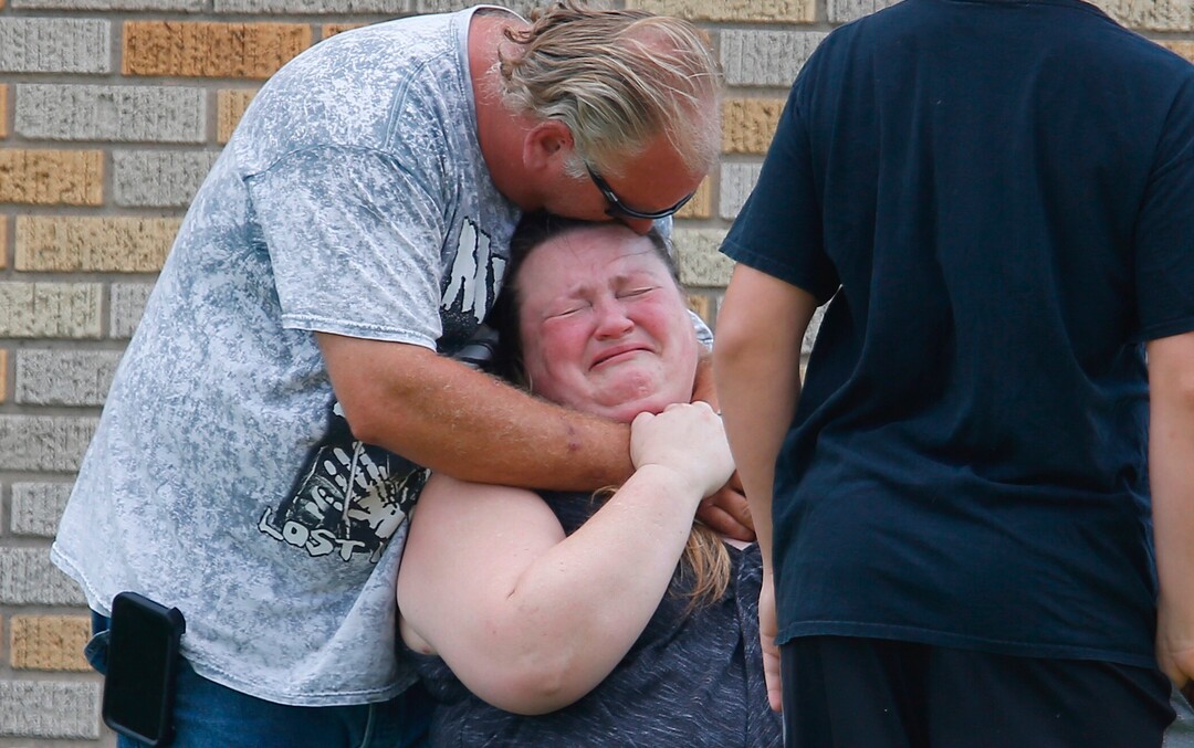 A man hugs a woman outside the Alamo Gym where parents wait to reunite with their children following a shooting at Santa Fe High School in Santa Fe, Texas, on Friday, May 18, 2018. (Michael Ciaglo/Houston Chronicle via AP)