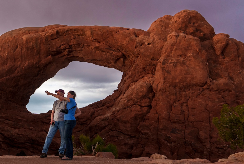 (Leah Hogsten | The Salt Lake Tribune)  A couple watches the sunset from the South Window in Arches National Park, Monday, May 15, 2023.