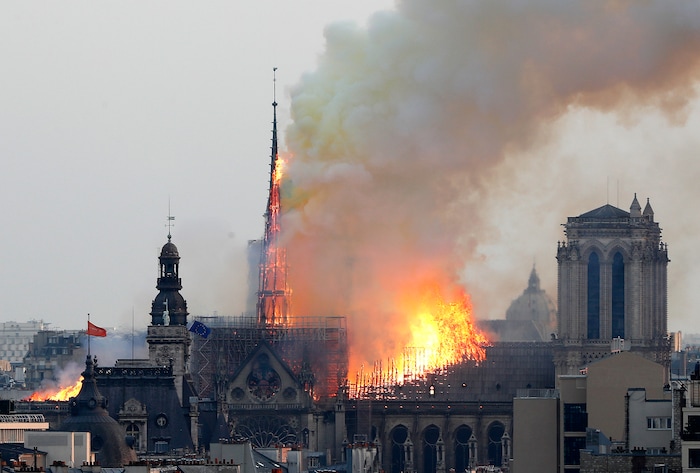 Flames rise from Notre Dame cathedral as it burns in Paris, Monday, April 15, 2019. Massive plumes of yellow brown smoke is filling the air above Notre Dame Cathedral and ash is falling on tourists and others around the island that marks the center of Paris. (AP Photo/Thibault Camus)