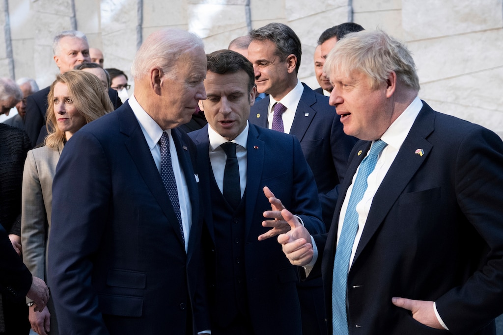 (Brendan Smialowski | Pool) U.S. President Joe Biden, left, talks with French President Emmanuel Macron and Briitish Prime Minister Boris Johnson, right, as they arrive at NATO Headquarters in Brussels, Thursday, March 24, 2022.