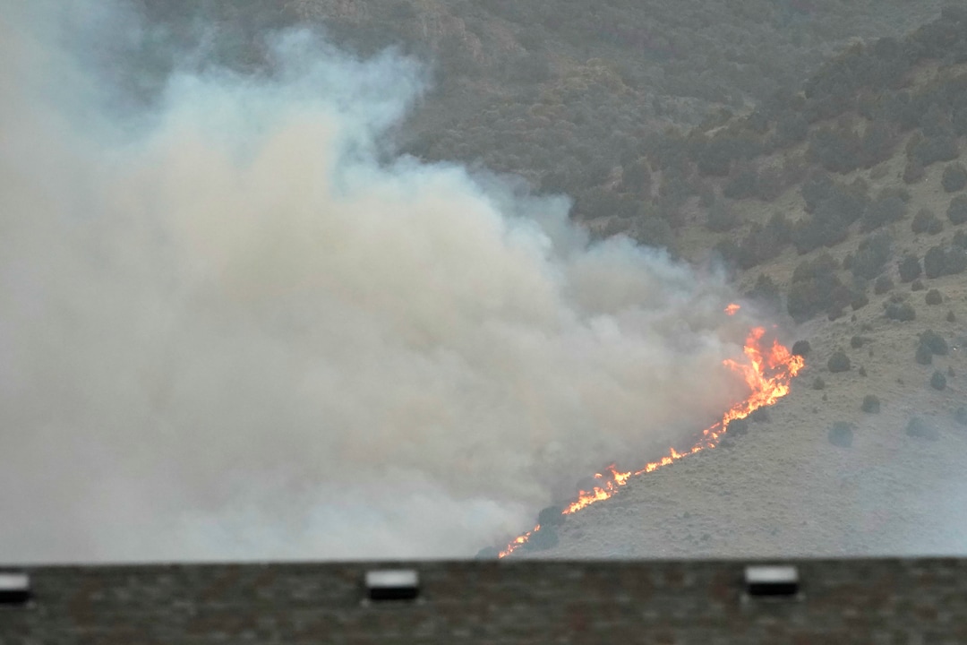 (George Frey  |  for The Salt Lake Tribune) Flames from a wildfire rise above homes in south Saratoga Springs on June 28, 2020.