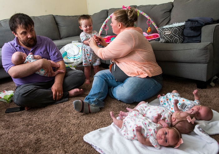 (Rick Egan  |  The Salt Lake Tribune)       Allen Glines holds Reese, as Kayla helps Parker with some lotion, while Oaklee, Lincoln, Jamesen lie on the blanket, at her home in Ogden, Saturday, June 15, 2019.