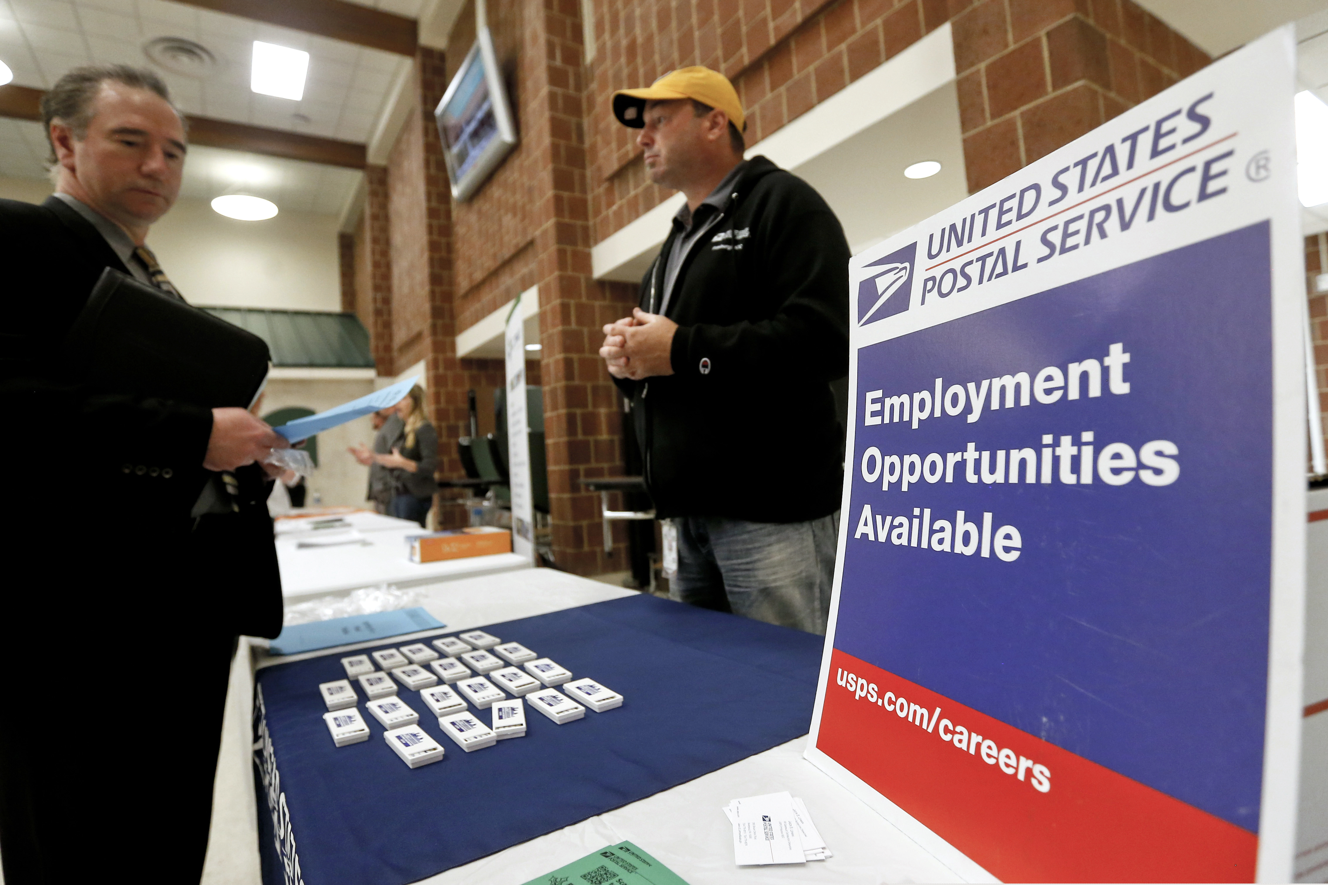 (Keith Srakocic | The Associated Press) In this Nov. 2, 2017, file photo a recruiter from the postal service, right, speaks with an attendee of a job fair in the cafeteria of Deer Lakes High School in Cheswick, Pa. Even with fear of a global economic slump depressing stock markets, Friday, Jan. 4, 2019 jobs report for December is expected to offer reassurance that the U.S. economy remains sturdy and on track to expand for a 10th straight year.