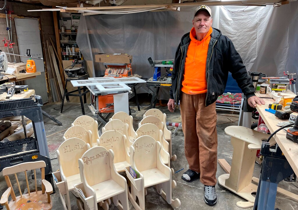 Jeff Hansen stands in his woodworking shop, located in a shed outside his home on Dec. 11, 2020, in South Weber, Utah, with some of the chairs he's made to donate to kids in need this holiday season. (Tim Vandenack/Standard-Examiner via AP)