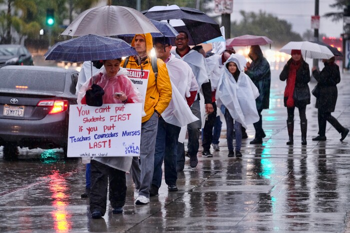 (Richard Vogel | The Associated Press)  Los Angeles teachers walk on a picket line in pouring rain in front of Los Angeles High School during a city-wide teacher strike on Monday, Jan. 14, 2019. Tens of thousands of Los Angeles teachers went on strike Monday after contentious contract negotiations failed in the nation's second-largest school district.