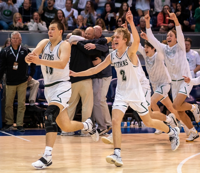 (Rick Egan | The Salt Lake Tribune) 
Olympus Titan, center, Jack Wistrcill (15) and Jordan Barnes (2) celebrate the Titan's win over the Wildcats, in the 5A State Championship game between Woods Cross and Olympus, at the Marriott Center in Provo, on Saturday, March 5, 2022. 