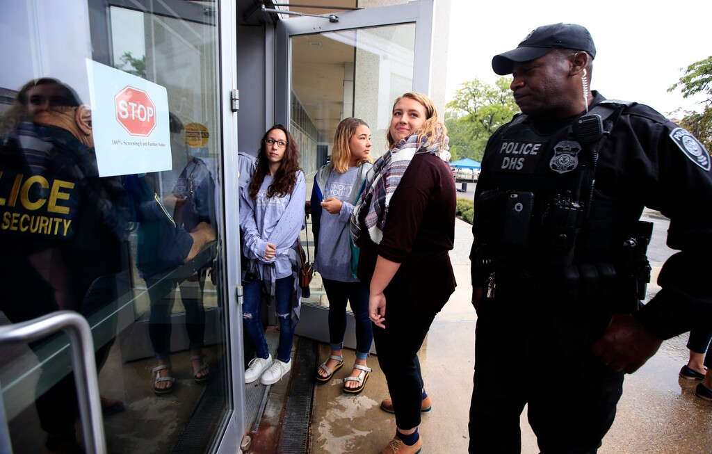 Survivors of sexual assault Faith Ferber, center and Sage Carson, second from right, together with a supporter of survivors Bailey Bystry, third from right, are met at the door of the Department of Education by security personnel as they try to hand signed petitions at the Department of Education that support the Dear Colleague Letter, just 24 hours before Betsy DeVos is expected to announce her Title IX plan in Washington, Wednesday, Sept. 6, 2017. (AP Photo/Manuel Balce Ceneta)