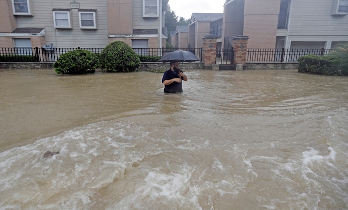 (David J. Phillip | The Associated Press) A man wades through floodwaters from Tropical Storm Harvey on Sunday, Aug. 27, 2017, in Houston, Texas.