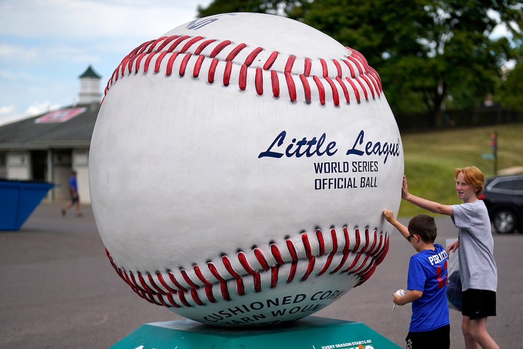 (Gene J. Puskar | AP) Little League baseball fans touch a giant baseball on display outside Lamade Stadium, sight of the Little League World Series baseball tournament in South Williamsport, Pa, Thursday, Aug. 17, 2022.
