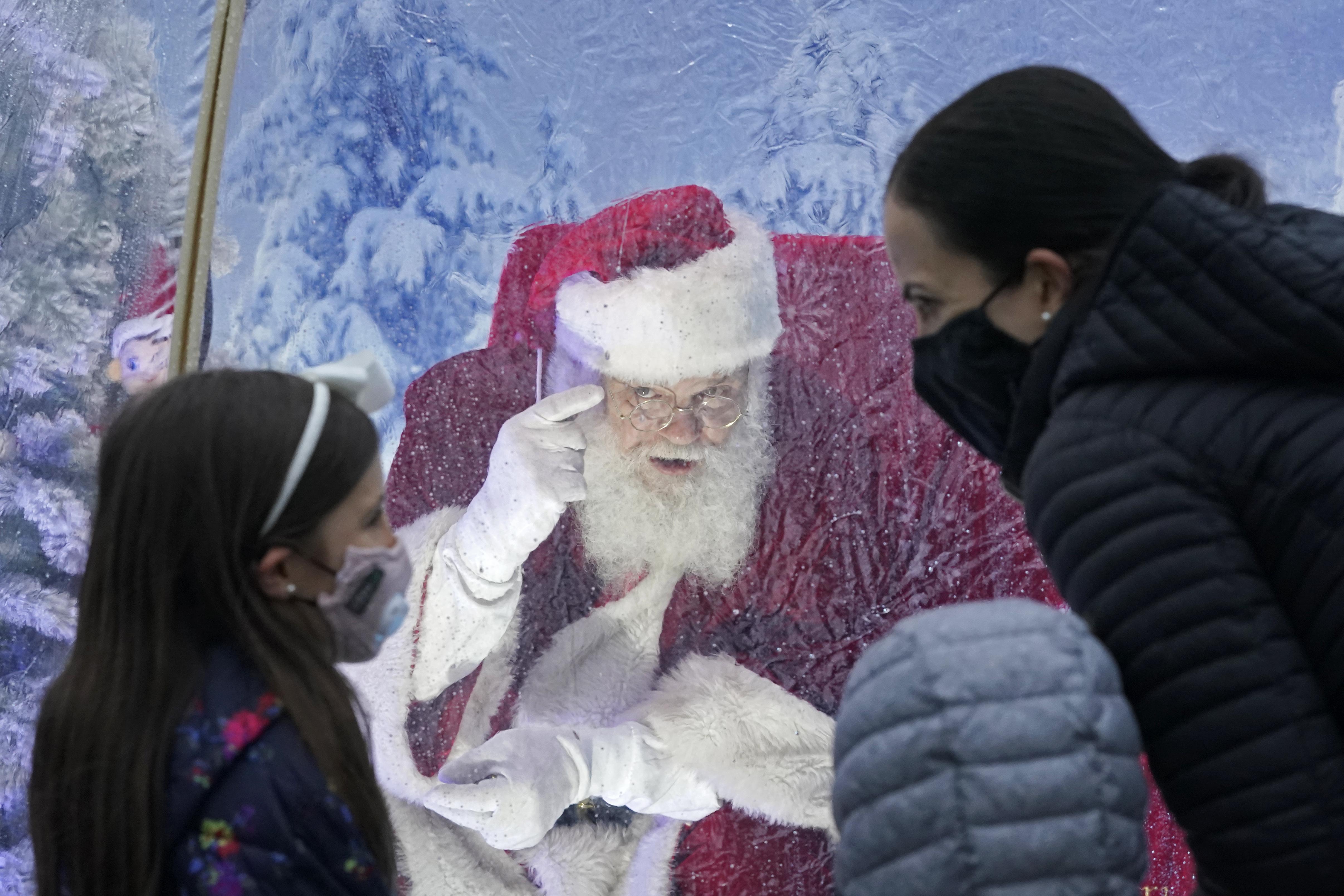 (Ted S. Warren | AP photo)

Santa, portrayed by Dan Kemmis, talks to a family wearing masks as he sits inside a protective bubble in Seattle's Greenwood neighborhood on Dec. 8, 2020.