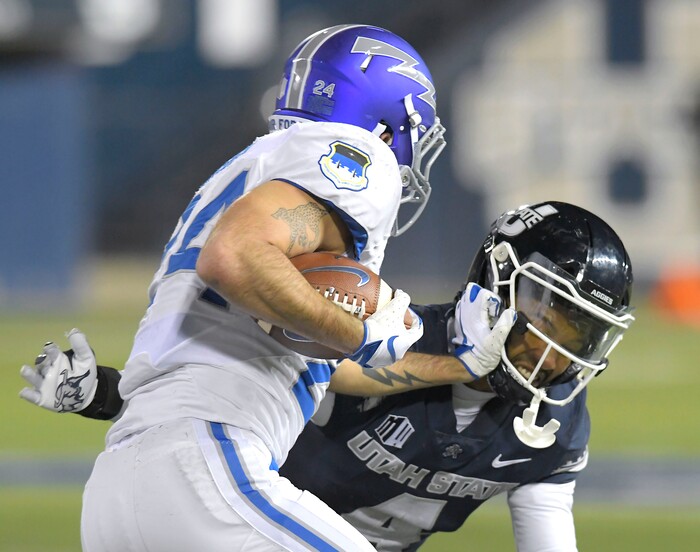 Air Force running back Kadin Remsberg (24) is tackled by Utah State safety Shaq Bond (4) during the first half of an NCAA college football game Thursday, Dec. 3, 2020, in Logan, Utah. (Eli Lucero/The Herald Journal via AP, Pool)