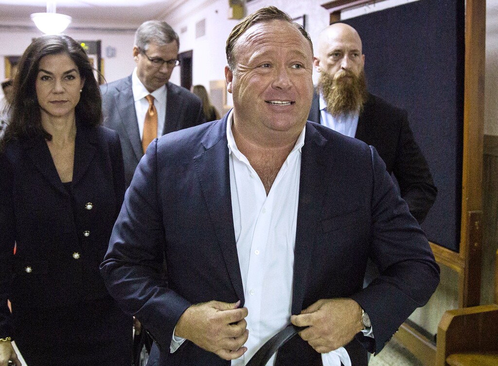 FILE - In this April 17, 2017, file photo, "Infowars" host Alex Jones arrives at the Travis County Courthouse in Austin, Texas. Jones filed a motion Friday, July 20, 2018, to dismiss a defamation lawsuit filed by families of some of the 26 people killed in the 2012 Sandy Hook school shooting in Newtown, Conn. The music streaming service Spotify says it has removed some episodes of “The Alex Jones Show” podcast for violating its hate content policy. The company said late Wednesday that it takes reports of hate content seriously and reviews any podcast or song reported by customers. (Tamir Kalifa/Austin American-Statesman via AP, File)