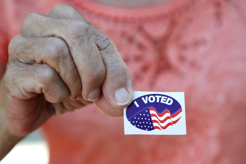 FILE - In this March 17, 2020, file photo Fran Drago shows her sticker after she voted in the Florida presidential primary in Cape Coral, Fla. Scrambling to address voting concerns amid a pandemic, election officials from Nevada to Florida are scaling back or eliminating opportunities for people to cast ballots in person. (AP Photo/Elise Amendola, File)