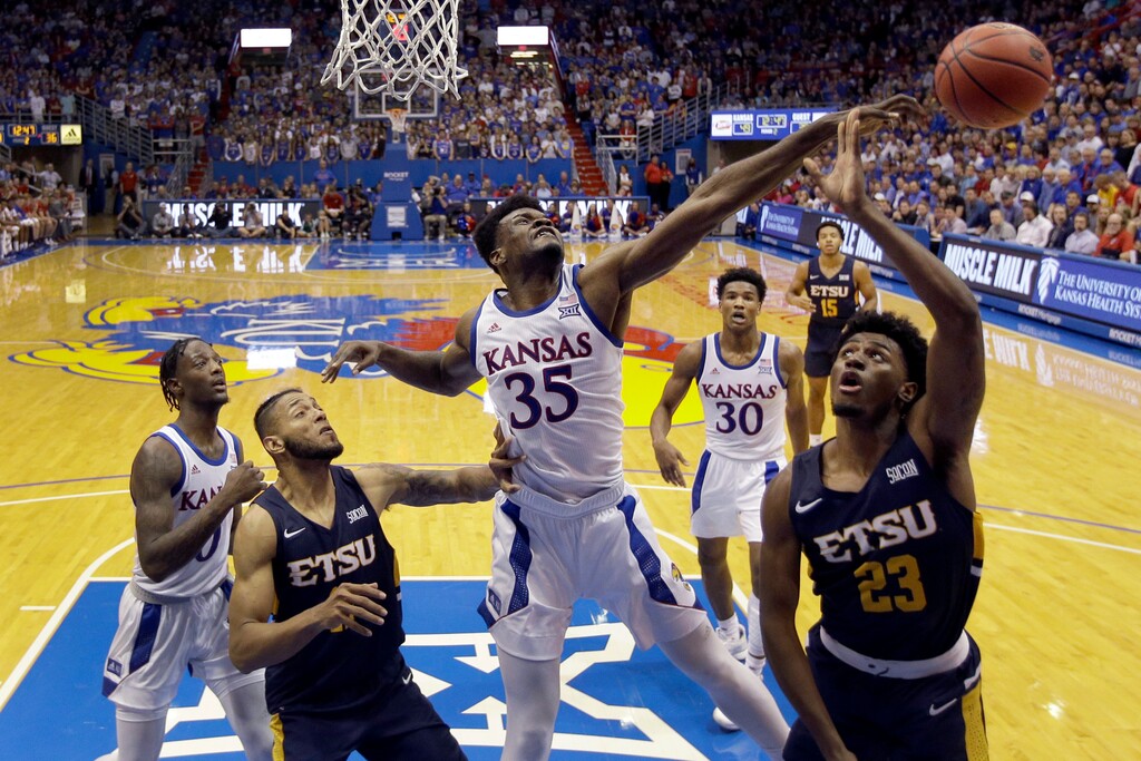 FILE - In this Nov. 19, 2019, file photo, Kansas center Udoka Azubuike (35) blocks a shot by East Tennessee State forward Vonnie Patterson (23) during the second half of an NCAA college basketball game in Lawrence, Kan. Azubuike was selected to the Associated Press All-Big 12 first team announced Tuesday, March 10, 2020. Azubuike was also named the AP Big 12 Player of the Year. (AP Photo/Charlie Riedel, File)