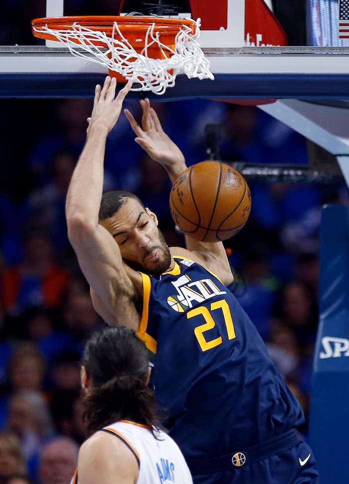 Utah Jazz center Rudy Gobert (27) dunks in front of Oklahoma City Thunder center Steven Adams in the first half of Game 1 of an NBA basketball first-round playoff series in Oklahoma City, Sunday, April 15, 2018. (AP Photo/Sue Ogrocki)