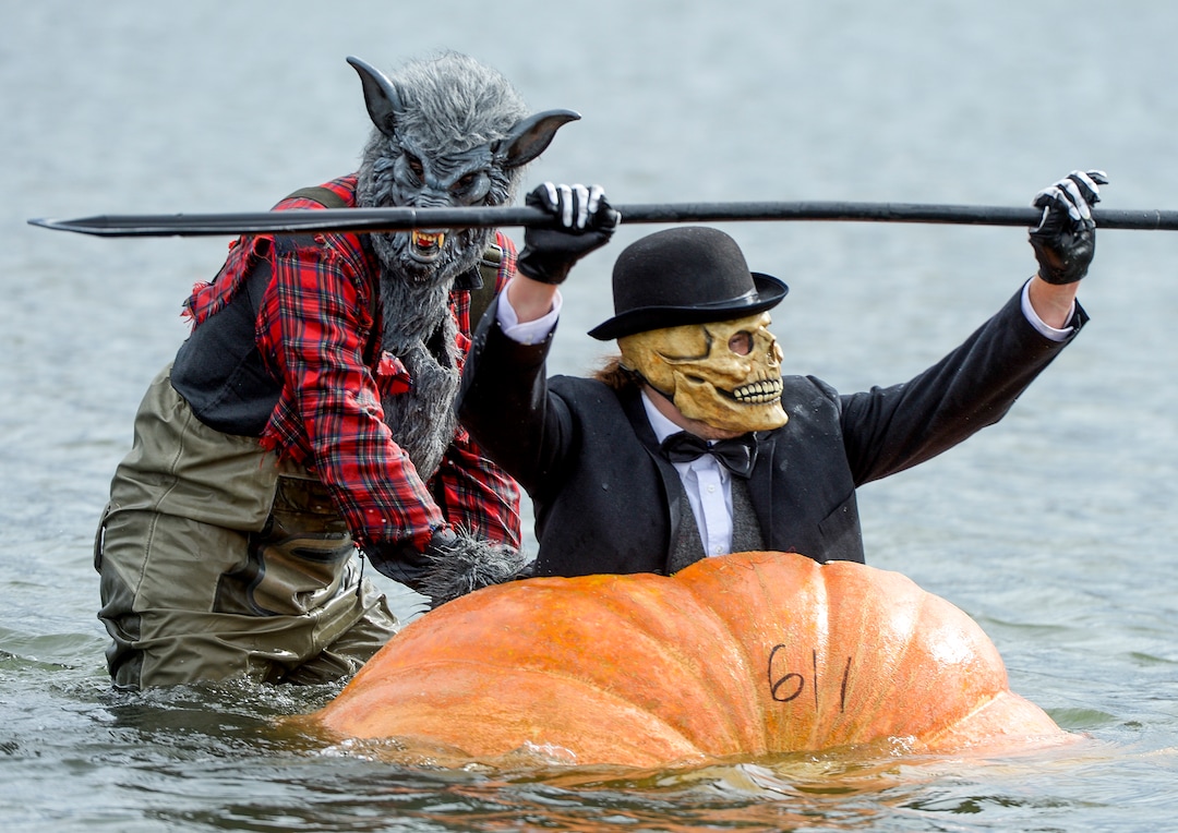 (Leah Hogsten  |  The Salt Lake Tribune) l-r Wolfman Tayne Mock helps his relay partner Skullman Jordan Freytag during the annual Giant Pumpkin Regatta, October 19, 2019 on Oquirrh Lake in Daybreak, South Jordan.