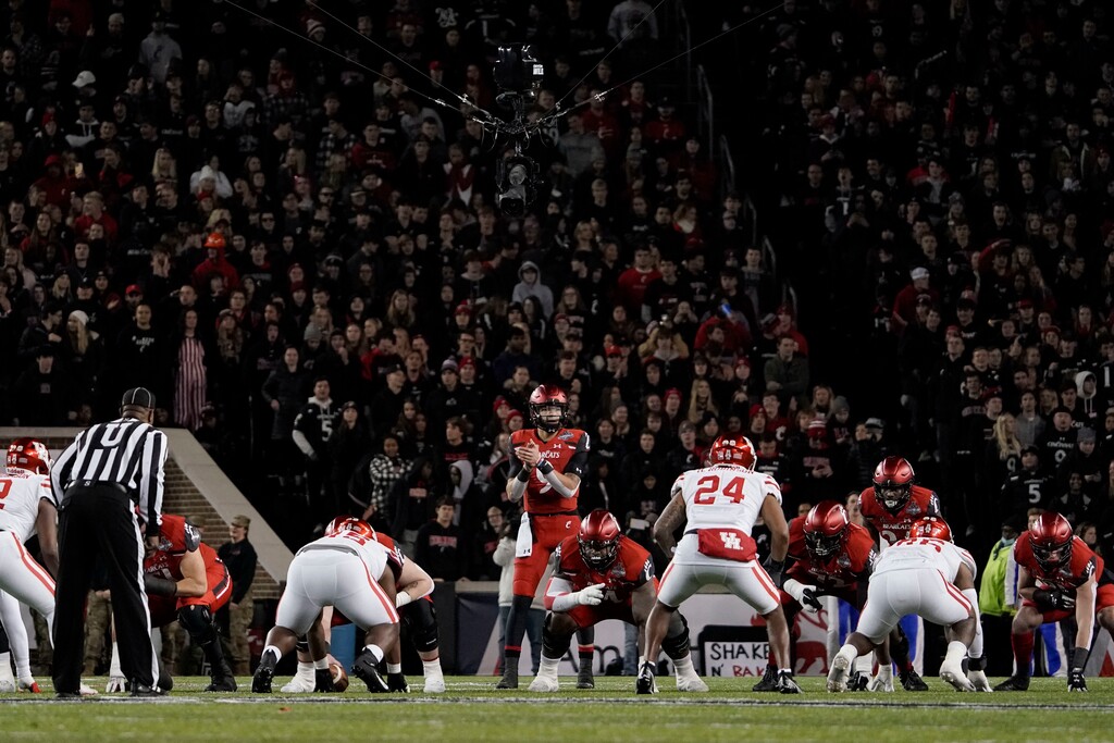 (Jeff Dean | AP) Cincinnati quarterback Desmond Ridder prepares to take the snap during the second half of an American Athletic Conference championship NCAA college football game against Houston on Dec. 4, 2021, in Cincinnati. The American Athletic Conference announced an agreement, Friday, June 10, 2022, with Cincinnati, Houston and UCF that paves the way for the schools to join the Big 12 in 2023.