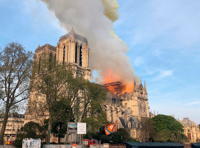 Notre Dame cathedral is burning in Paris, Monday, April 15, 2019. Massive plumes of yellow brown smoke is filling the air above Notre Dame Cathedral and ash is falling on tourists and others around the island that marks the center of Paris. (AP Photo)