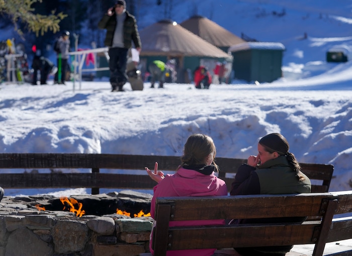 (Bethany Baker | The Salt Lake Tribune) Two people sit in front of an open fire at the bottom of a run at Sundance Resort near Provo on Thursday, Dec. 14, 2023.