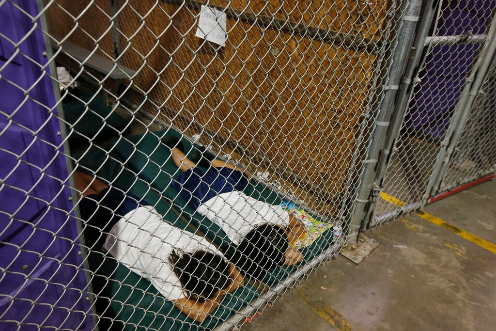 (AP Photo/Ross D. Franklin, Pool) In this June 18, 2014 file photo, two female detainees sleep in a holding cell, as the children are separated by age group and gender, as hundreds of mostly Central American immigrant children are being processed and held at the U.S. Customs and Border Protection Nogales Placement Center in Nogales, Ariz.  President Donald Trump has seized on an error by liberal activists for tweeting photos of detainees at the U.S.-Mexico border in steel cages and blamed the current administration for separating immigrant children from their parents.  The photos were taken by The Associated Press in 2014, when President Barack Obama was in office.