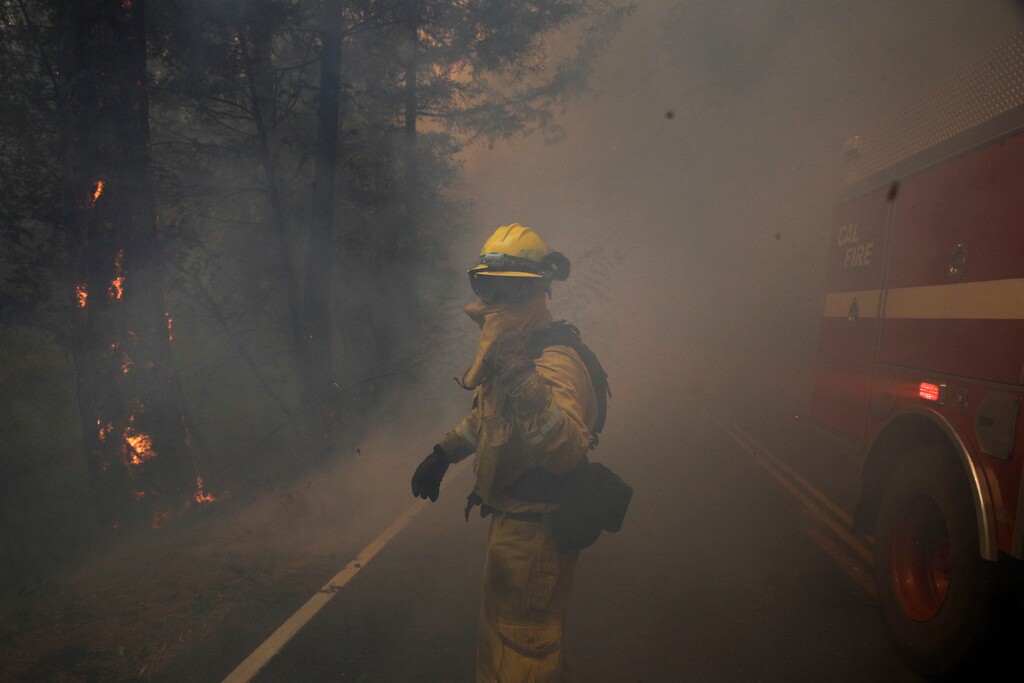 A firefighter gestures to his colleagues as he walks through thick smoke from a wildfire Thursday, Oct. 12, 2017, near Calistoga, Calif.  (AP Photo/Jae C. Hong)
