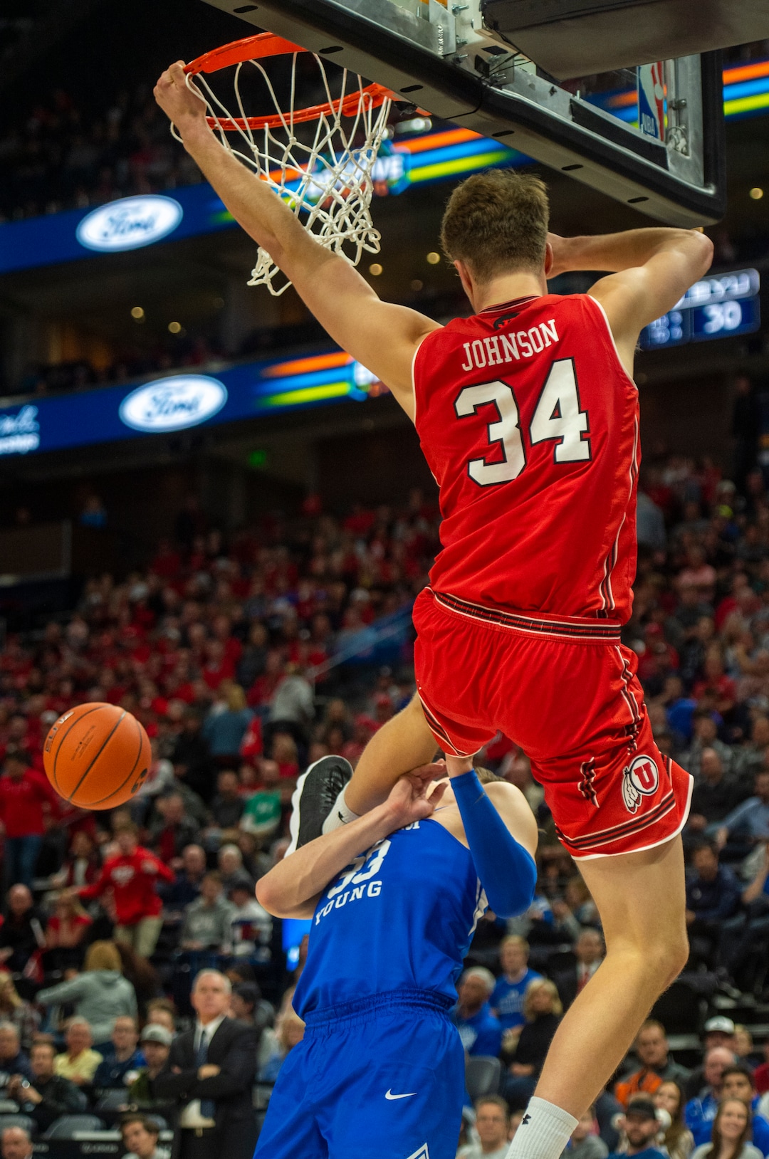 (Rick Egan  |  The Salt Lake Tribune)   Utah Utes center Jayce Johnson (34) dunks the ball and takes out against the Brigham Young Cougars forward Dayton Nixon (33) on the play in basketball action in the Beehive Classic, between against the Brigham Young Cougars and Utah Utes, a the Vivint Smart Home Arena, Saturday December 8, 2018.