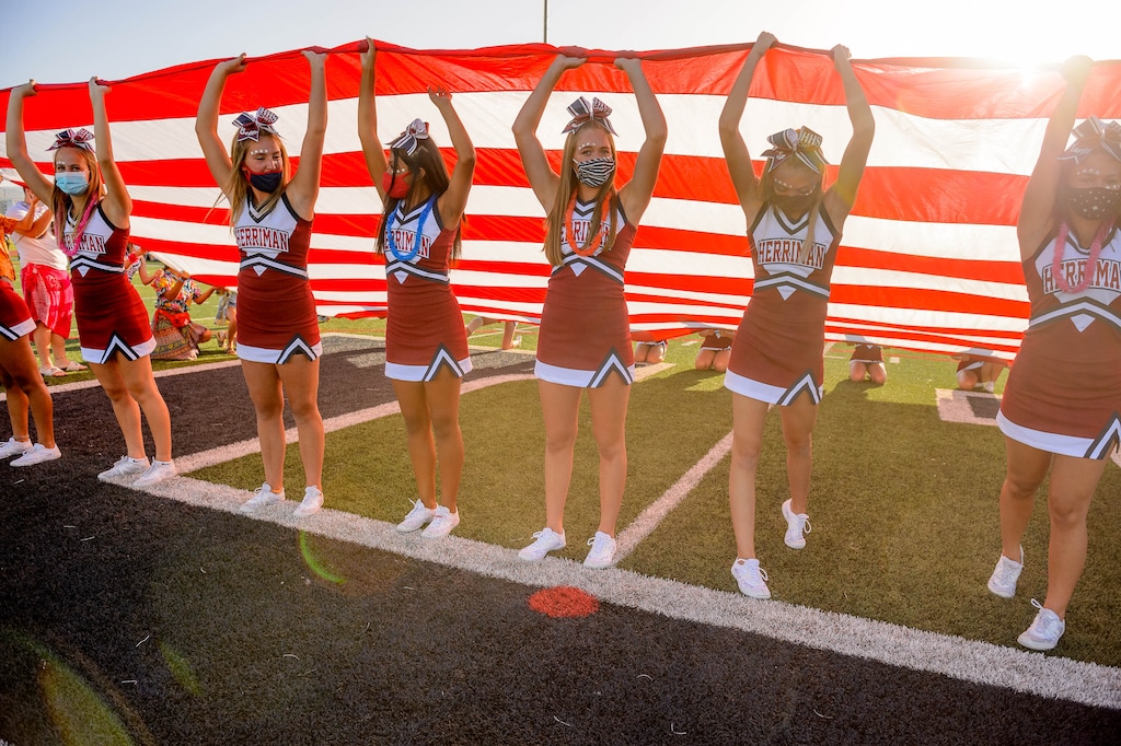 (Trent Nelson  |  The Salt Lake Tribune) Herriman cheerleaders hold a flag during the National Anthem while hosting Davis High School football, in Herriman on Thursday, Aug. 13, 2020.