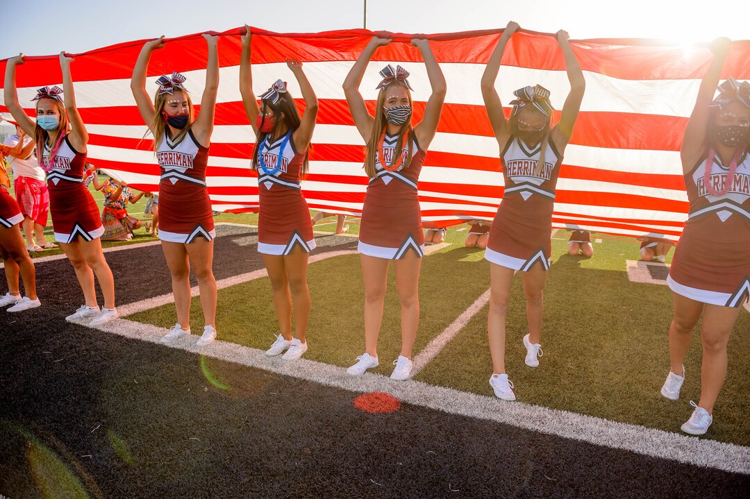 (Trent Nelson  |  The Salt Lake Tribune) Herriman cheerleaders hold a flag during the National Anthem while hosting Davis High School football, in Herriman on Thursday, Aug. 13, 2020.